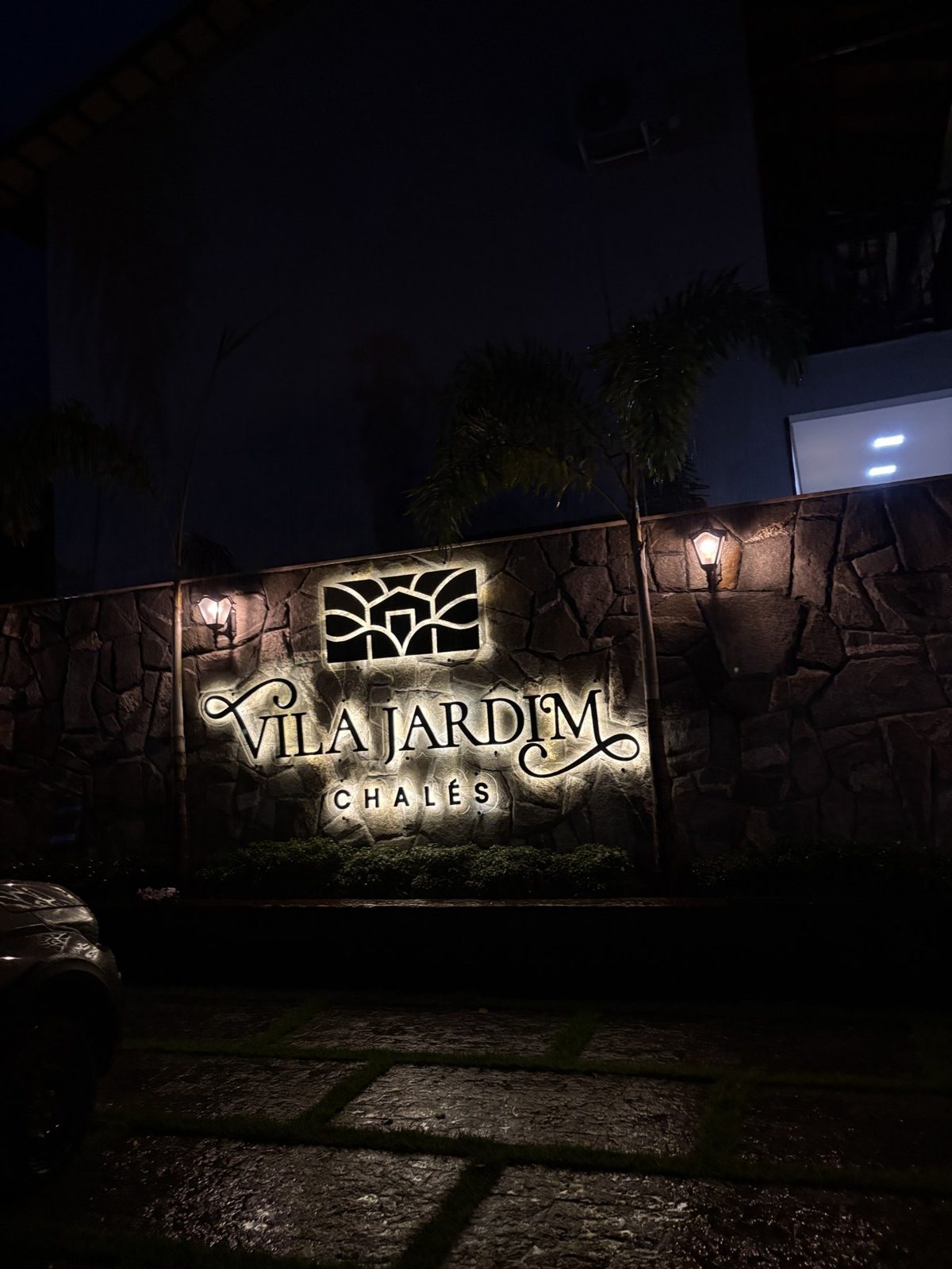 Fachada da Vila Jardim Chalés iluminada à noite